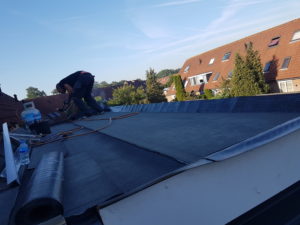 dakdekker bezig met het dak